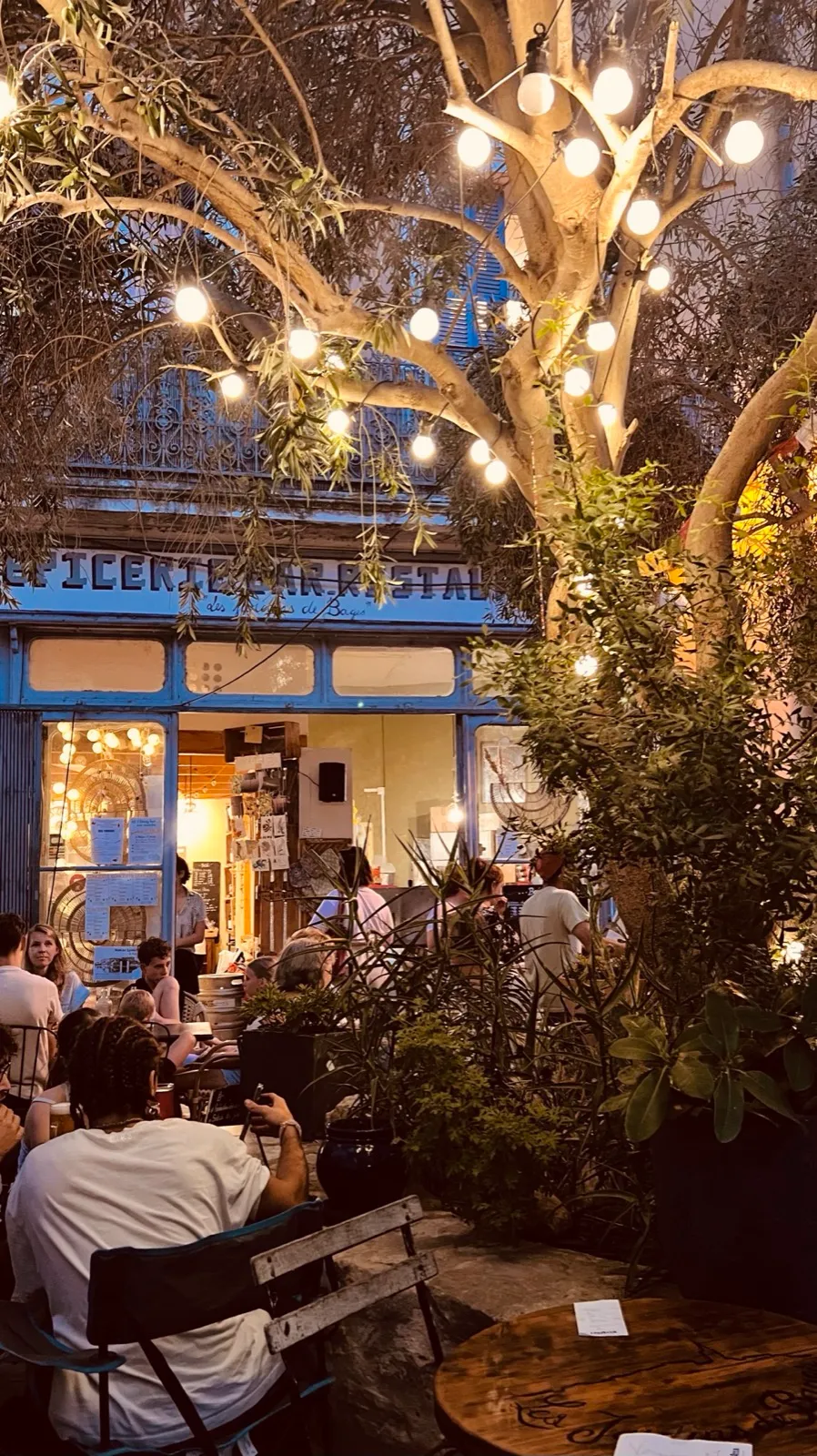 Die abendliche Terrasse von Les Jardins de Bages mit Lichterketten im Olivenbaum