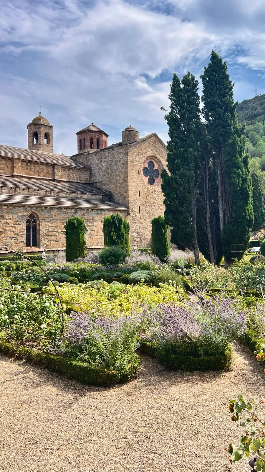 Der Rosengarten der Abbaye de Fontfroide mit Zypressen vor der Abteikirche