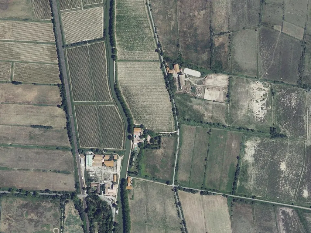 Aktuelles Luftbild: das Haus mit Pool am Ostufer des Kanals, links Rebzeilen, rechts Weiden und der Weg nach Osten
