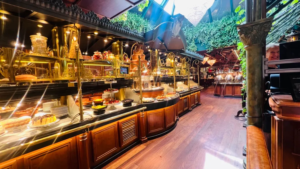 Blick durch die Buffet-Reihen unter dem begrünten Glasdach