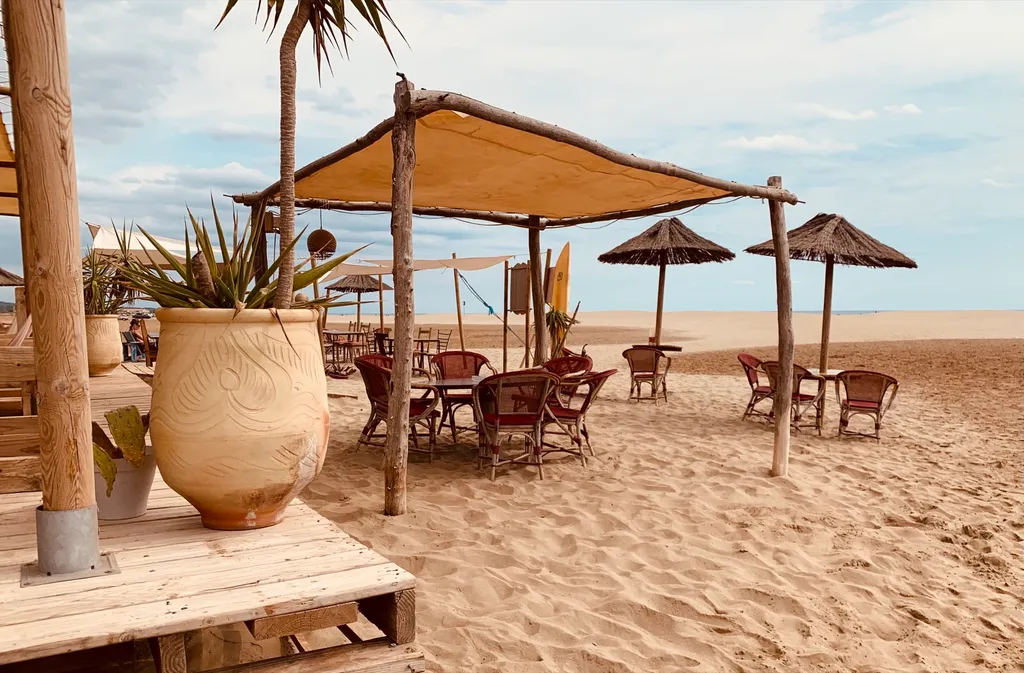 Strandbar am Plage de Mateille in Gruissan mit Treibholz-Sonnensegeln und Strohschirmen
