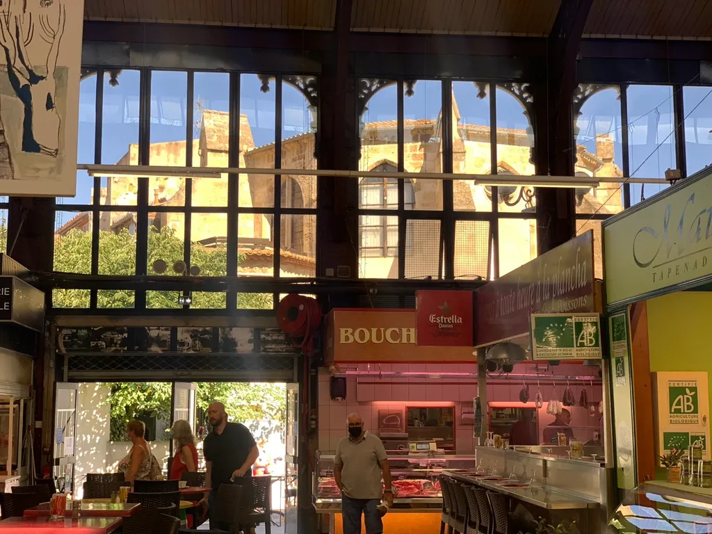 Blick durch die Glasfenster der Halle auf die Kathedrale von Narbonne