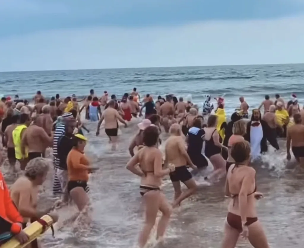 Hunderte Menschen laufen am 1. Januar an der Plage des Chalets ins Mittelmeer, viele in Kostümen