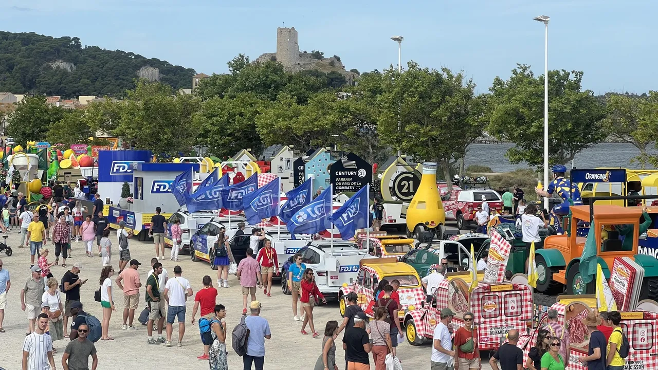 Die Werbekarawane der Tour de France auf dem Platz in Gruissan, dahinter der Turm Barberousse auf seinem Felsen