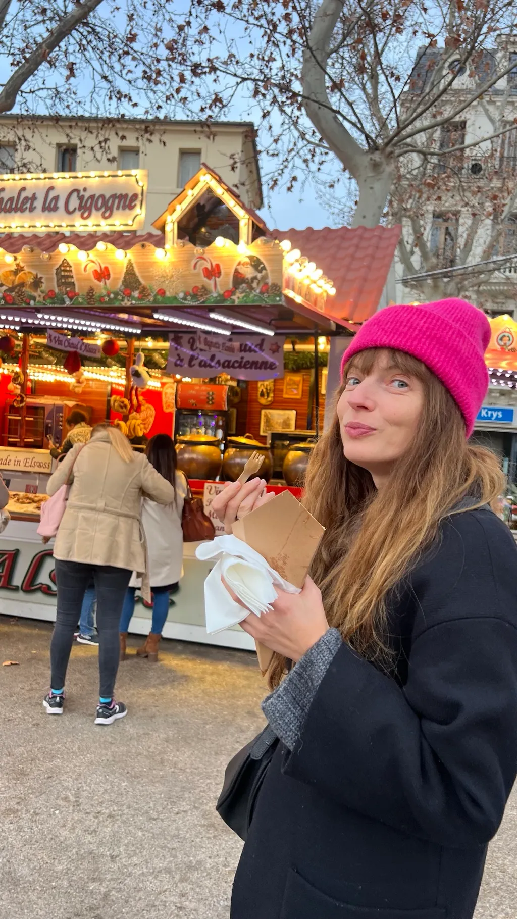 Caroline mit pinkfarbener Mütze vor einem elsässischen Vin-chaud-Stand auf dem Weihnachtsmarkt von Narbonne